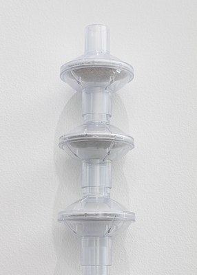 Detail of a hanging sculpture showing how each piece interlocks with the next, and showing the underside of the filter is slightly gray and dusty, while the top side is clean and white.