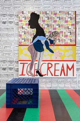 Another image from a different angle showing the milk crate and the large painting on its other side. On stretched canvas, painted fabric and painted paper has been collaged or sewn to depict a woman bending over and clutching her lower back or butt. Behind her, the silhouette of a man faces the other direction. The background of the wall work is broken up into three sections. The top two thirds are made up of small individual drawings of candy, applied to the canvas like wallpaper or flyers. A red striped line of fabric separates a yellow middle section in the painting with large white circles of fabric applied. On closer inspection, we can see that the circles have drawn details to resemble buttons. Another red stripe of fabric differentiates the bottom section of the painting. It has a white background and the word "ice cream" is written in all capital red letters.