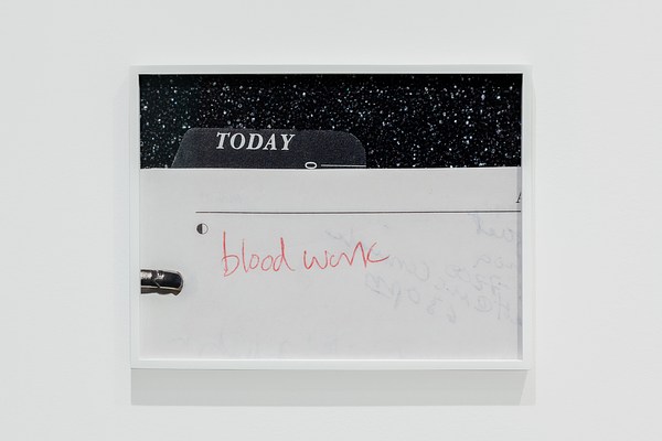 Framed photo shows “bloodwork” hand-written in red on white paper beneath a black tab titled “TODAY” in white type.