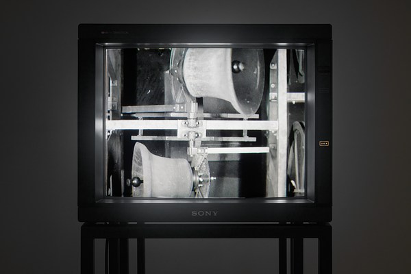 Close view of a video  monitor showing a black and  white image of two carillon bells  ringing horizontally in opposite  directions.