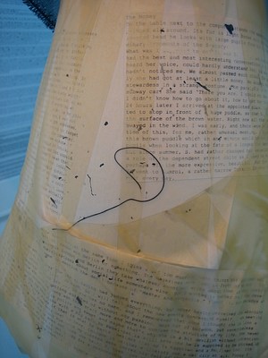 A close up of the lampshade covered with text, yellowing tape and various pen squiggles and dots.