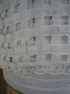 Another detail of the gray loose weave fabric. The fabric makes a loose net or grid and in the open squares text shows through from a paper below.