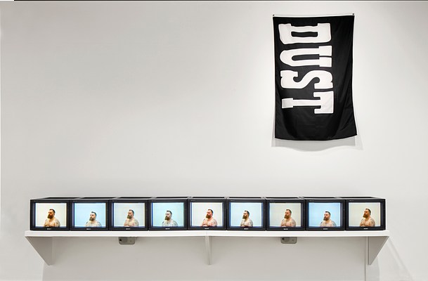 Nine repeating small screens with an image of a shirtless man and a black tapestry to the right above the screens that reads "DUST" in large, bold letters.&nbsp;