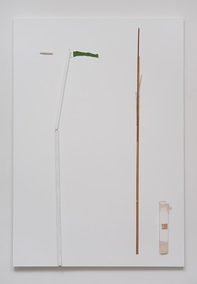 Close view of a painting seen in previous installation images hanging on a white wall. The painting is in portrait format, and primed in white. In the lower left half of the painting, we can see a vertical white-painted wooden stick mounted directly onto the canvas. It ends just above mid-height of the painting, from where a similar stick about half as long, extends at a slight angle to the right. At the top of this stick, a white piece of paper in the shape of a pennant with green paint on it extends to the right, whereas to the left, we can see a severed tortillon, a drawing tool, mounted onto the canvas. The composition looks a little like a plant. To the left in the canvas, we can see a wooden stick mounted parallel to the white wooden sticks. At the top, smaller wooden sticks have been attached. To the right of this, in the bottom right corner of the painting, we can see a smaller and wider vertical rectangular piece of canvas stapled to the canvas. At its top and bottom edge, we can see raw canvas, and at its center, a brown square, possibly packing tape. The composition make the objects look like sea reed. Below the painting, we can see a subtle drop shadow on the wall.